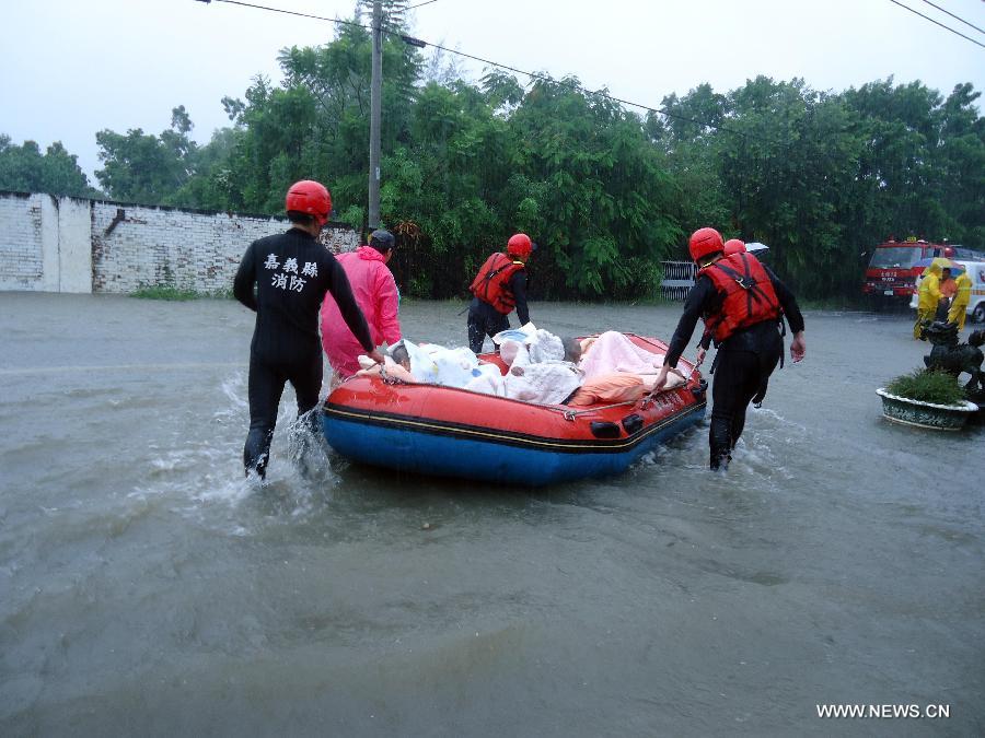 Rescuers transfer a man trapped by floods to safe area in Chiayi County, southeast China's Taiwan, on Aug. 29, 2013