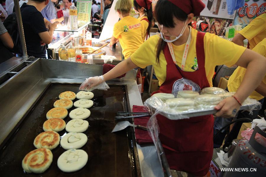A girl cooks scallion pancakes during the 2015 Taiwan Culinary Exhibition (TCE) in Taipei, southeast China's Taiwan, July 17, 2015.