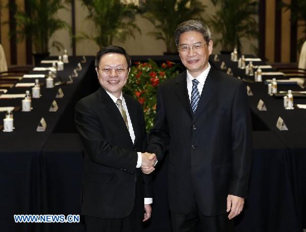 Zhang Zhijun (R), head of the State Council Taiwan Affairs Office, shakes hands with Wang Yu-chi, Taiwan's mainland affairs chief, before their formal meeting, in Nanjing, capital of east China's Jiangsu Province, Feb. 11, 2014. The Chinese mainland and Taiwan's chief officials in charge of cross-Strait affairs met here on Feb. 11 afternoon for the first time since 1949. (Xinhua/Shen Bohan)