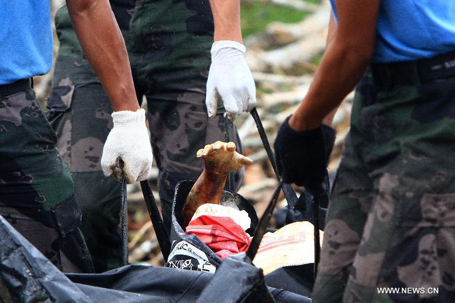 Rescuers carry the bodies of the victims of Typhoon Haiyan in Tacloban, the Philippines, Nov. 12, 2013.