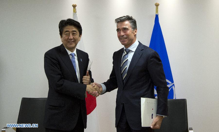 Japanese Prime Minister Shinzo Abe (L) and NATO Secretary-General Anders Fogh Rasmussen shake hands after signing the Individual Partnership and Cooperation Program (IPCP) during a meeting at NATO's headquarters, in Brussels, Belgium, May 6, 2014.