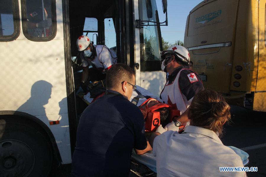 Image provided by Vanguardia newspaper of Saltillo shows a member of the Red Cross moving an injured person to an ambulance after a multiple crash, in Saltillo, Coahuila, northern of Mexico, on Aug. 14, 2014. At least 98 persons were reported injured in the accident involving at least four vehicles transporting employees of different corporations, according to local press.