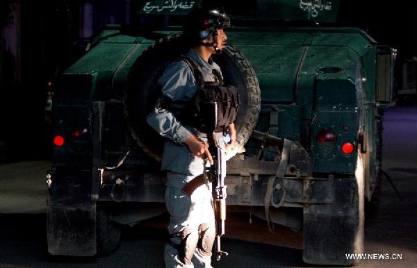 An Afghan policeman stands guard close to the site of an attack in Kabul, Afghanistan, May 14, 2015. Some nine people, including four attackers, were killed during a shoot out at a guesthouse in Afghan capital Kabul overnight Wednesday, an official source said on Thursday. (Xinhua/Ahmad Massoud)